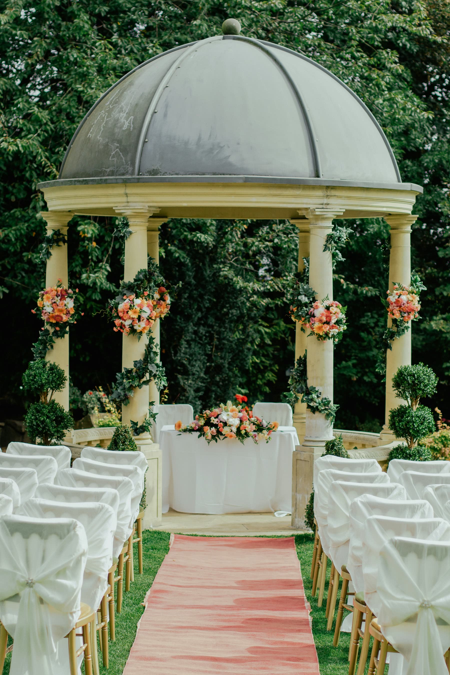 Garden gazebo dressed with white and blush floral arrangements